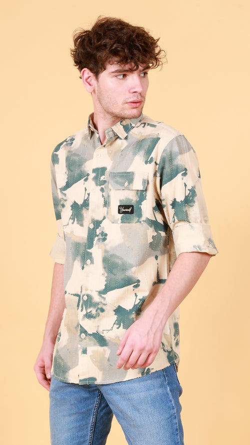 Person wearing a camouflage shirt with a visible brand logo on a beige background