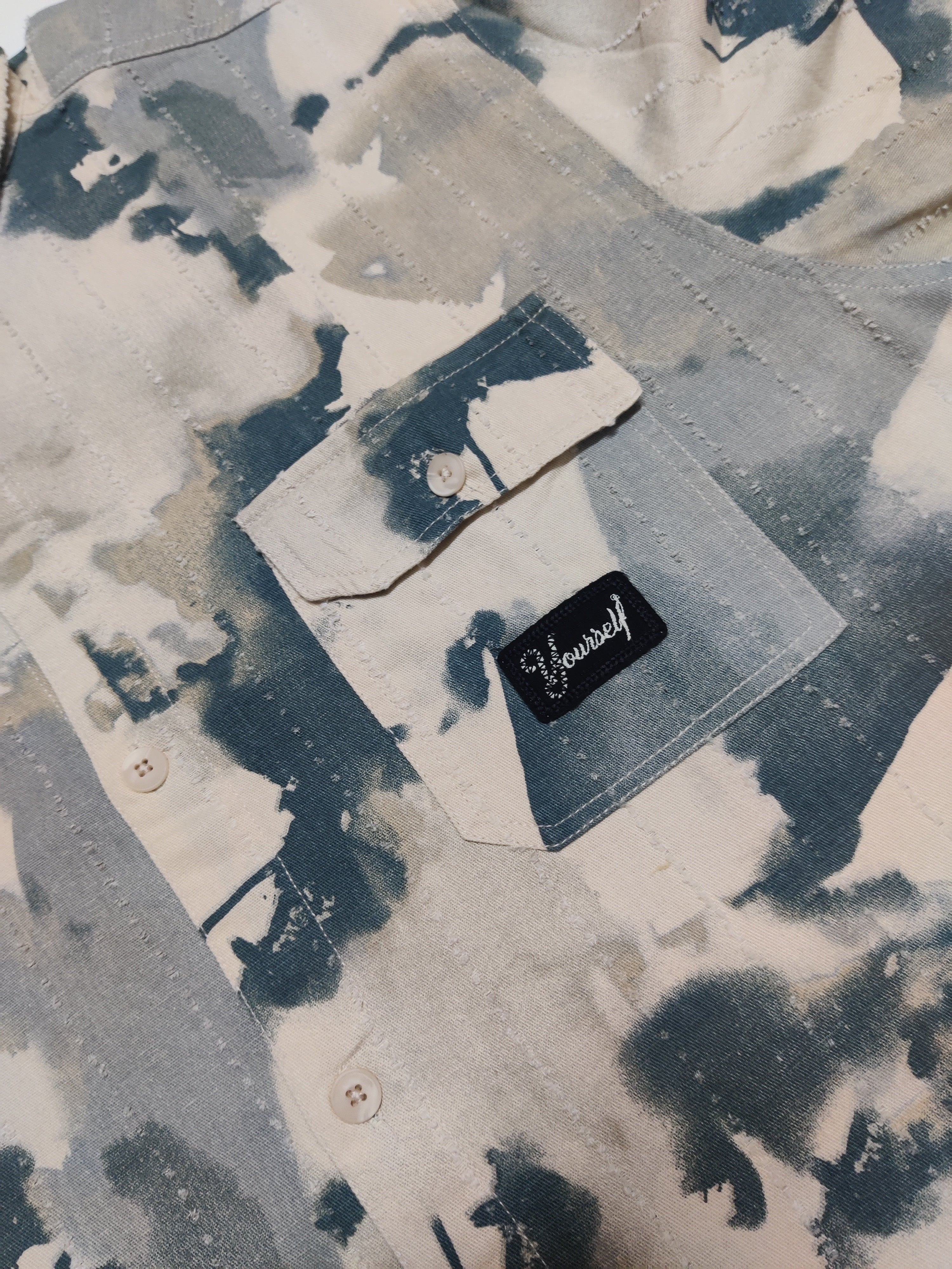 Denim jacket with a brand label on a textured background