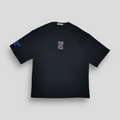 Black t-shirt with a chenille-embroidered patch on the front and a DTF-printed abstract graphic on the back, featuring a deep blue Jugrrnaut logo on the right sleeve.