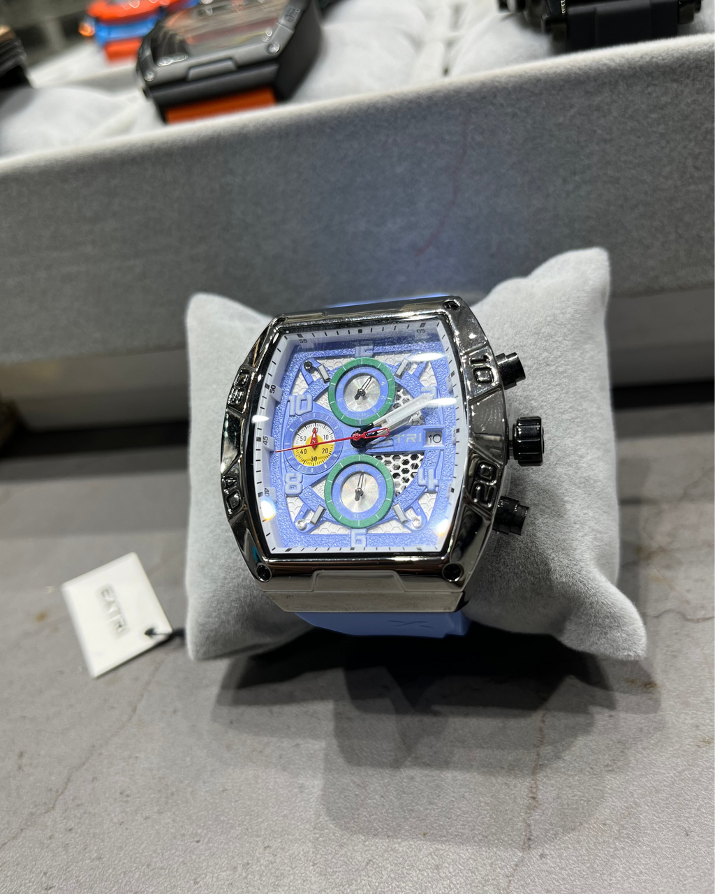 Luxury watch with a unique design on a gray cushion, blurred background