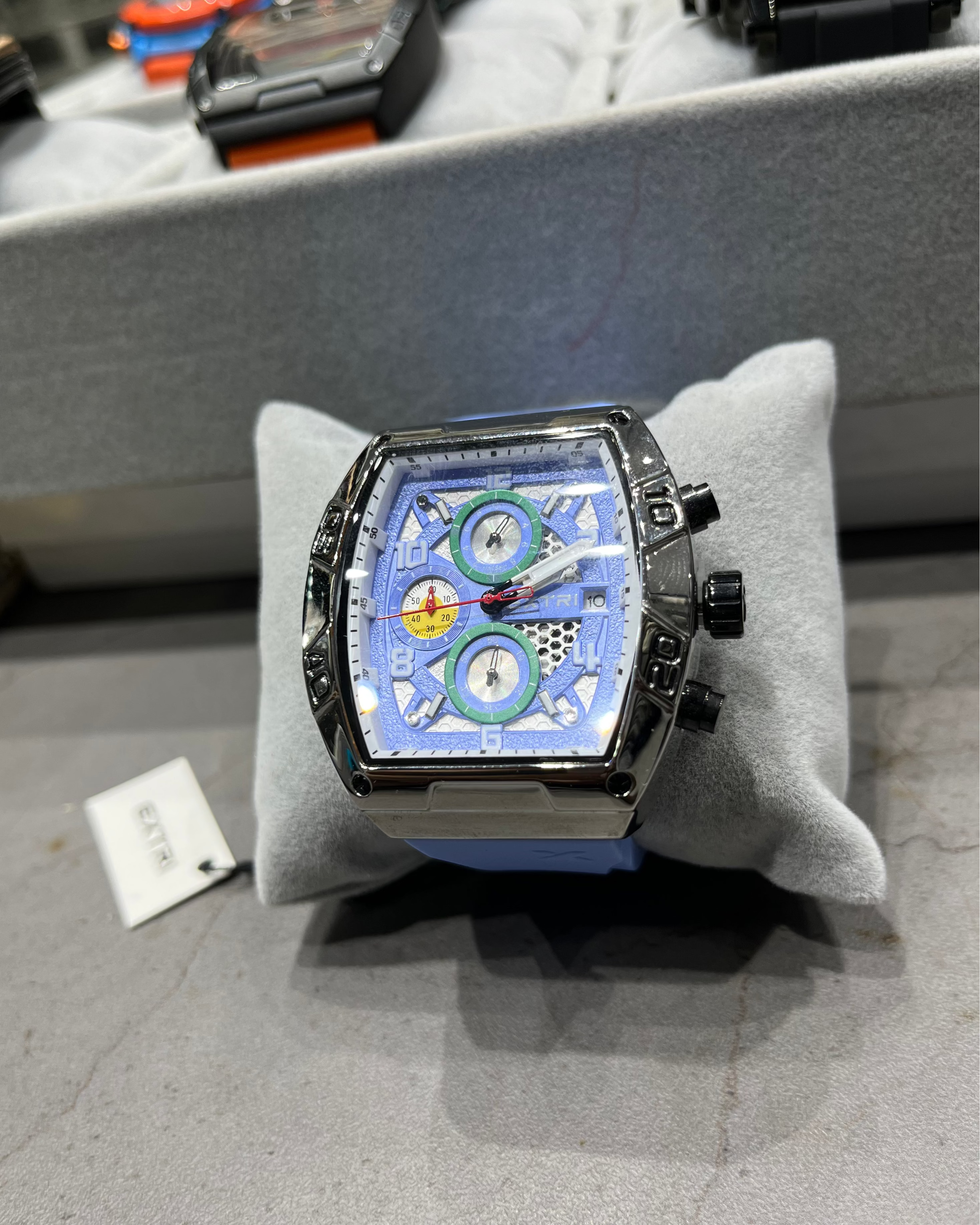 Luxury watch with a unique design on a gray cushion, blurred background