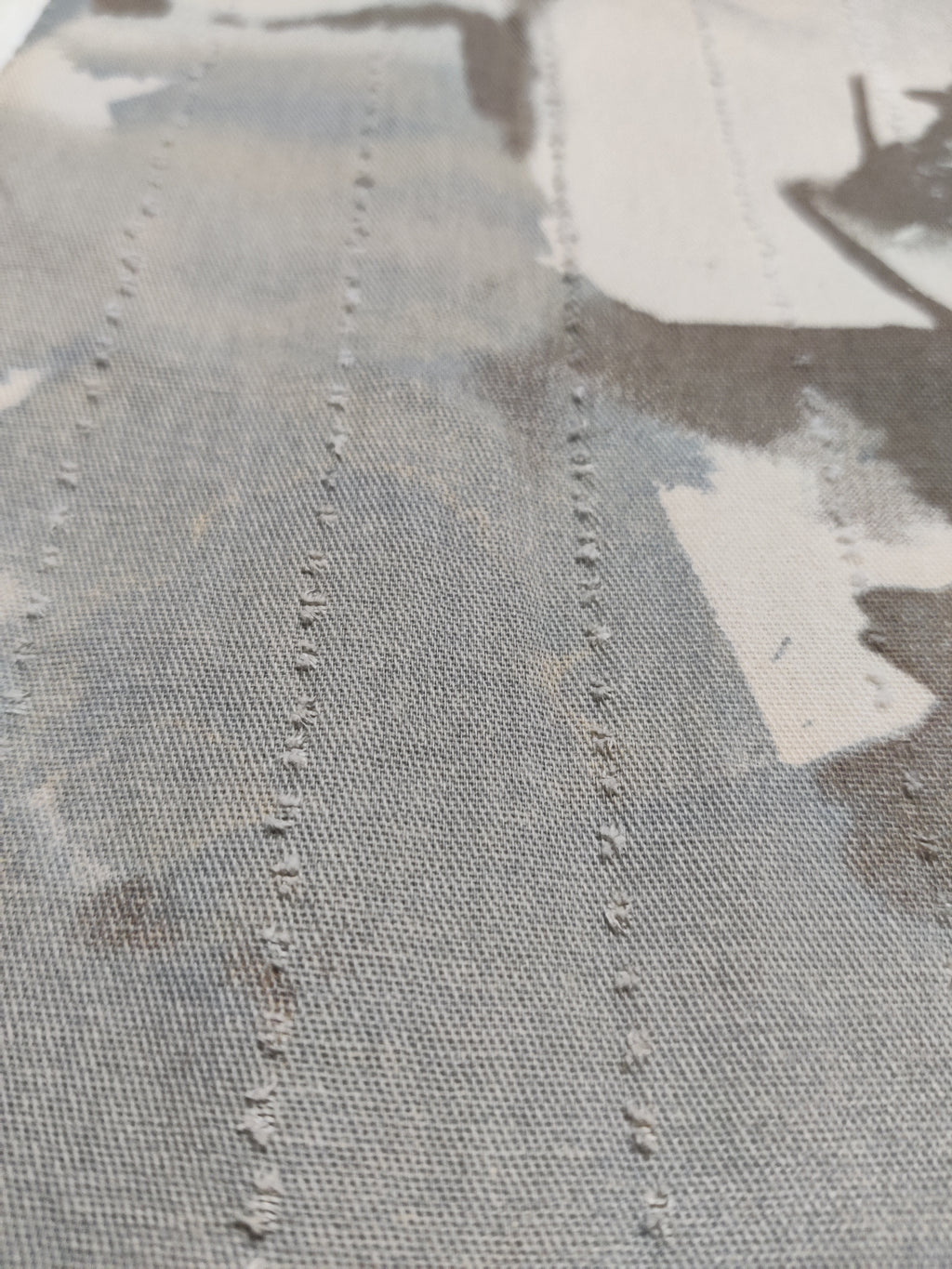 Close-up of a textured fabric surface with visible stitching details.