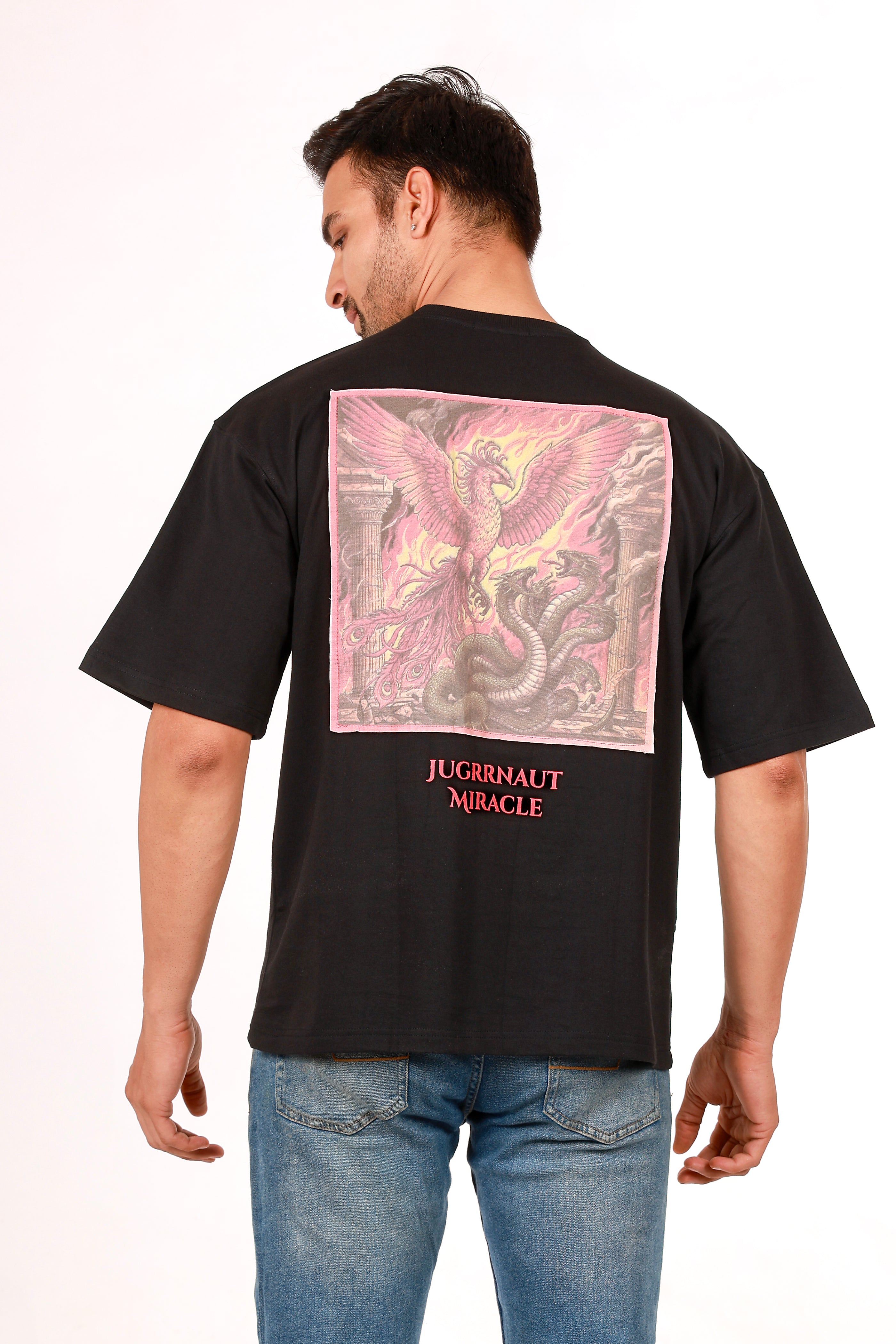Man wearing a black t-shirt with a colorful graphic on the back, standing against a white background.