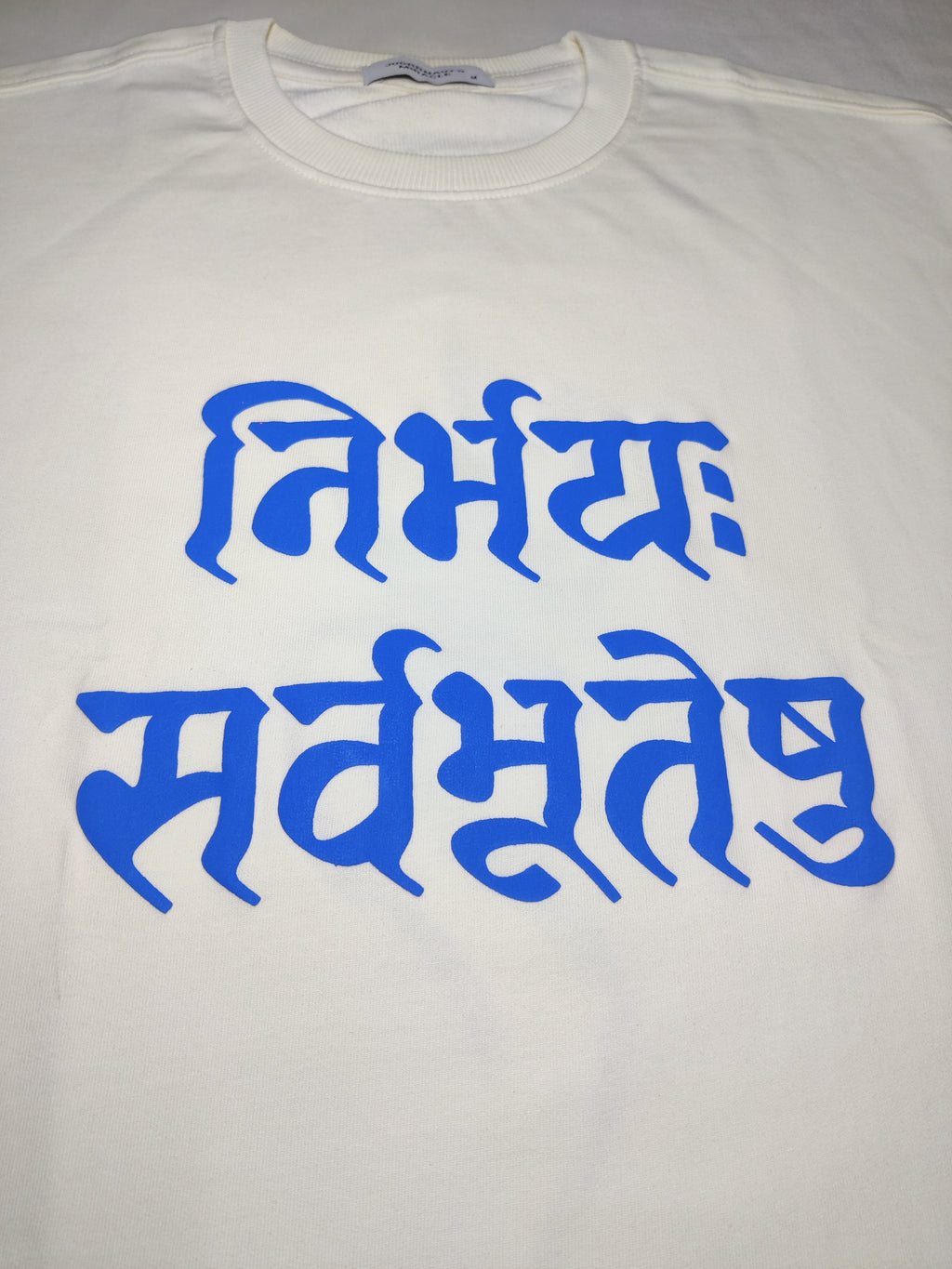 White t-shirt with blue text on a plain background