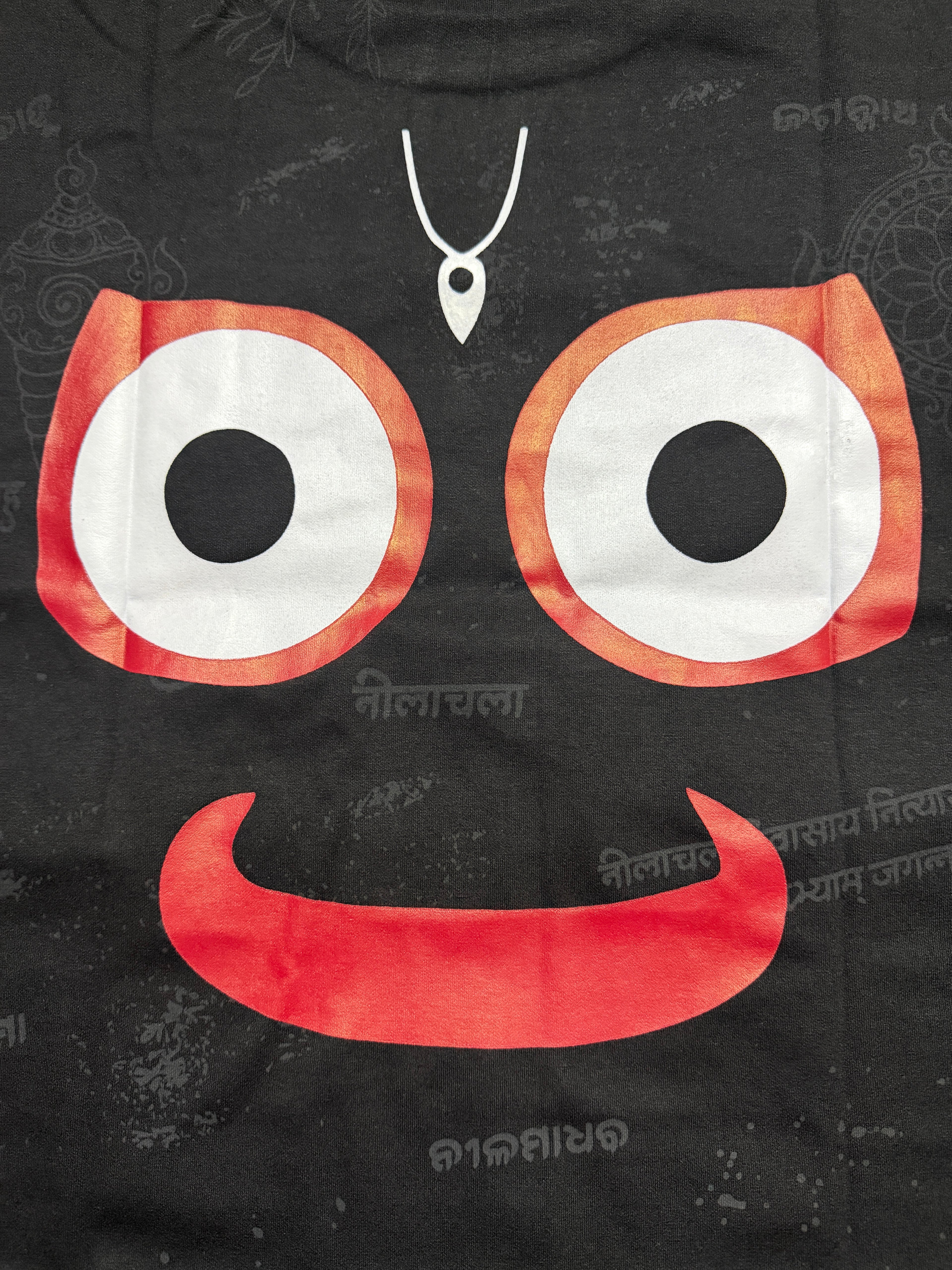 Black hoodie with a cartoonish face design featuring large eyes and a mouth on a dark background.