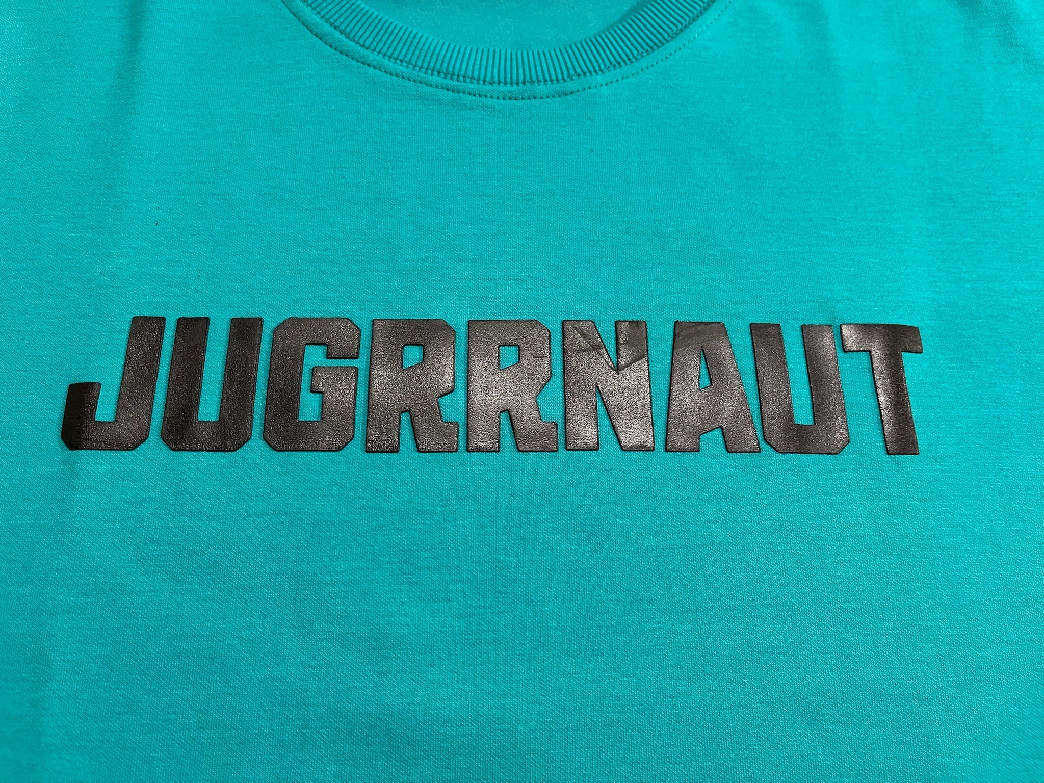 Teal sweatshirt with 'JUGRRNAUT' logo in black on a teal background