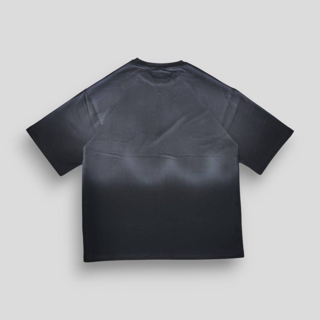 Black t-shirt with grey ombre sprayed  on a light gray background