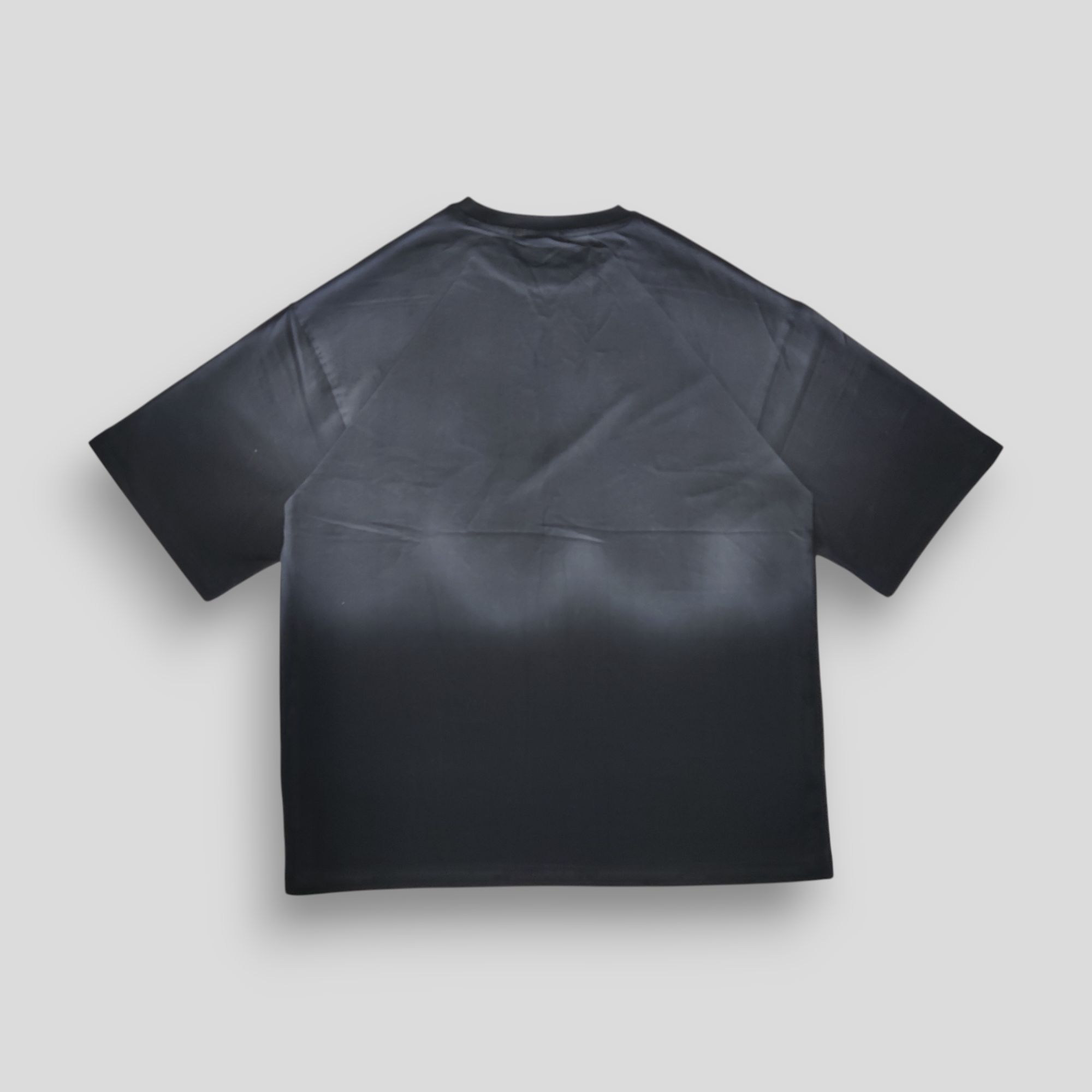 Black t-shirt with grey ombre sprayed  on a light gray background