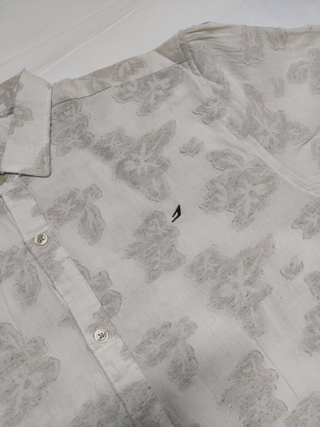 Light gray floral patterned shirt on a white background