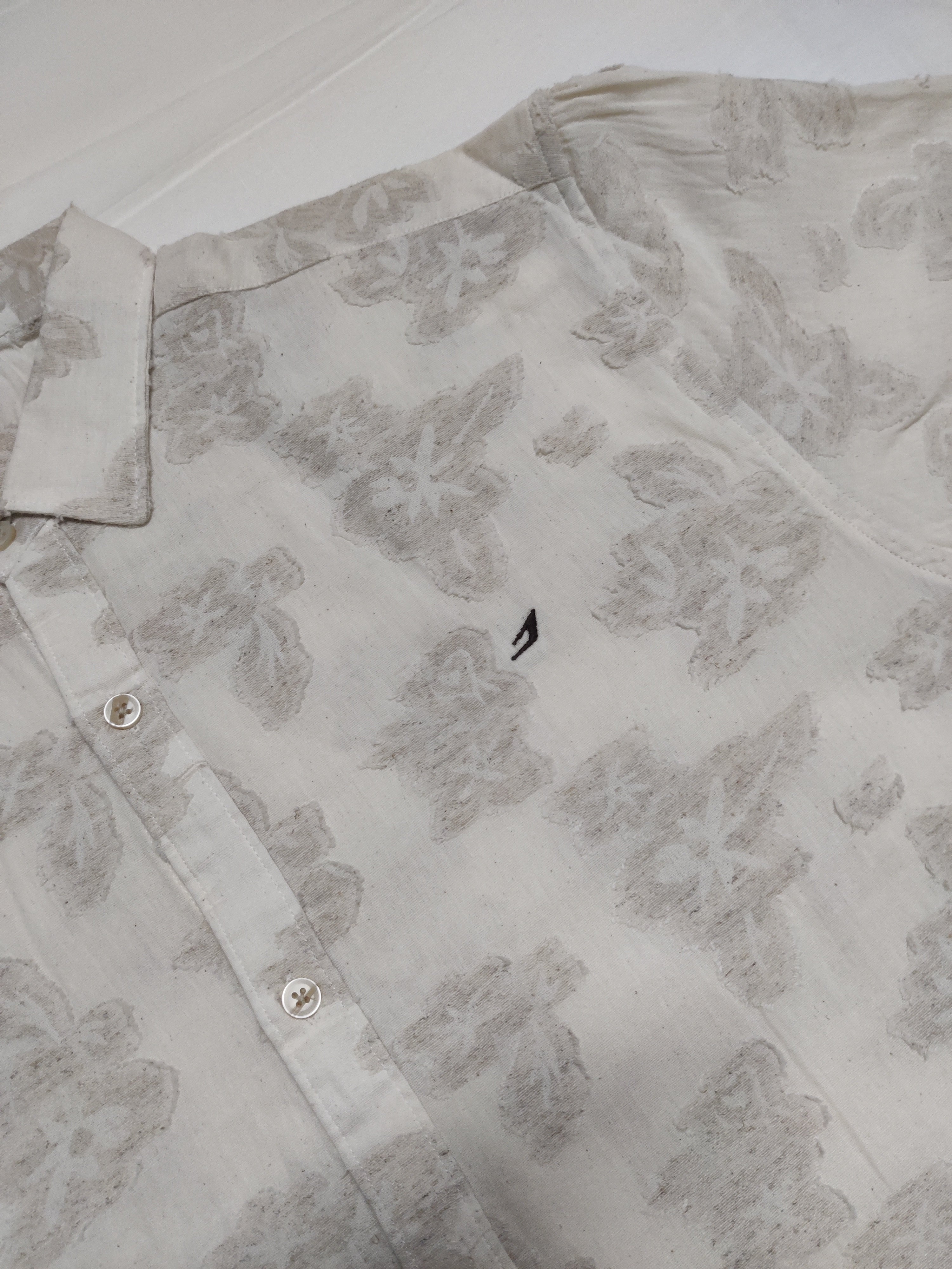Light gray floral patterned shirt on a white background