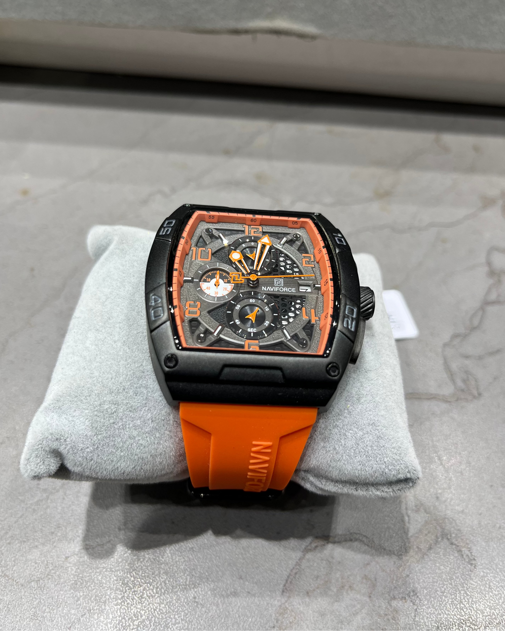 Watch with orange and black design on a gray surface