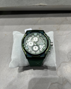 Green watch on a gray cushion with a gray background