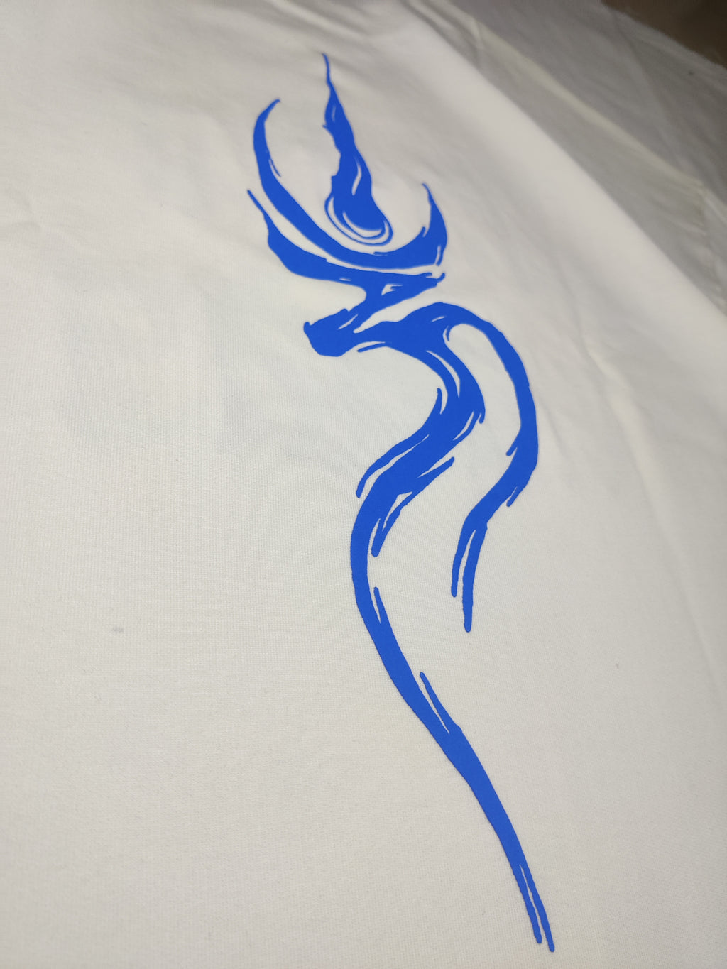 blue om tattooed on the back of a beige tshirt