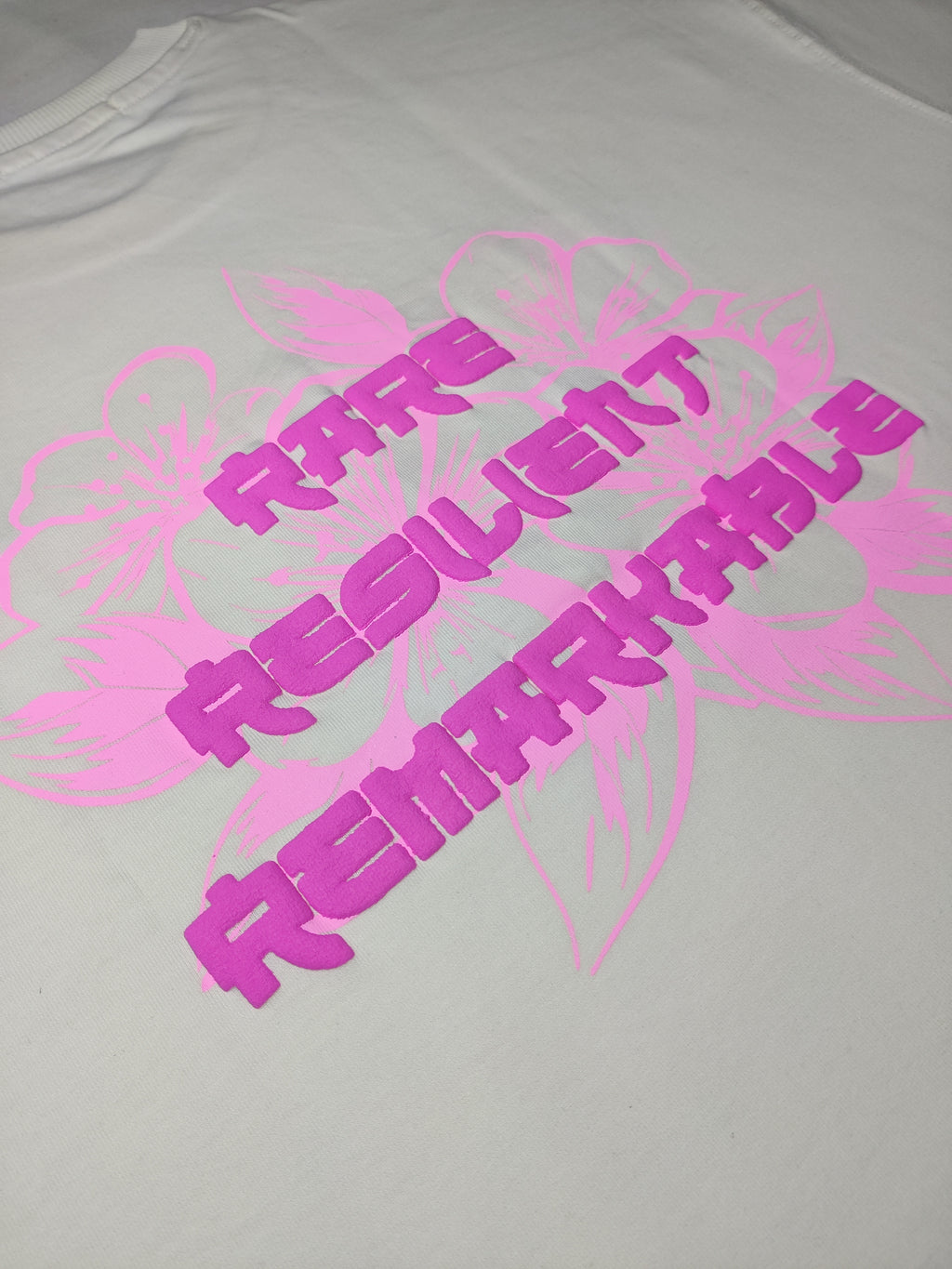 Gray t-shirt with pink motivational text design on a plain background