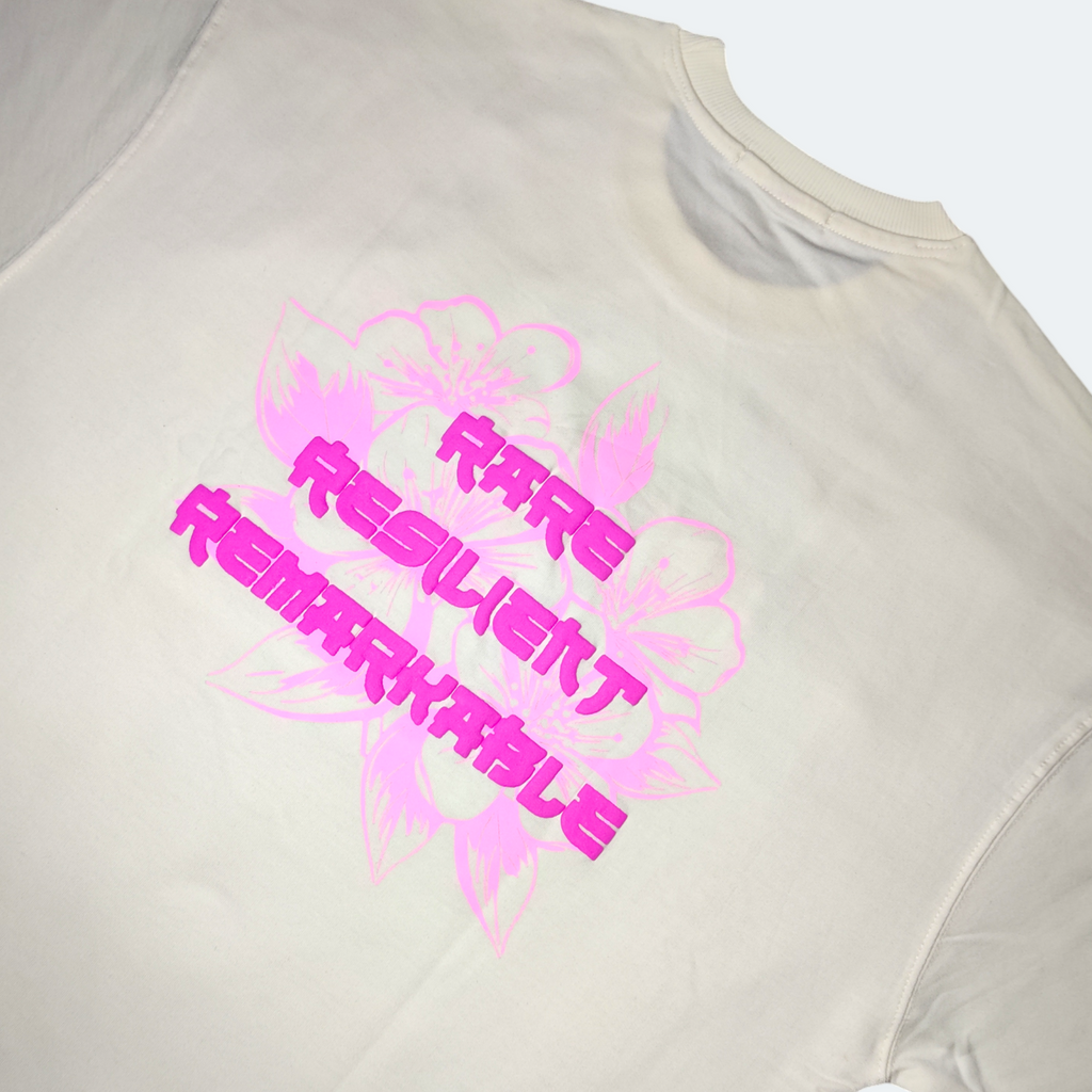 Beige t-shirt with pink and black motivational text on a white background