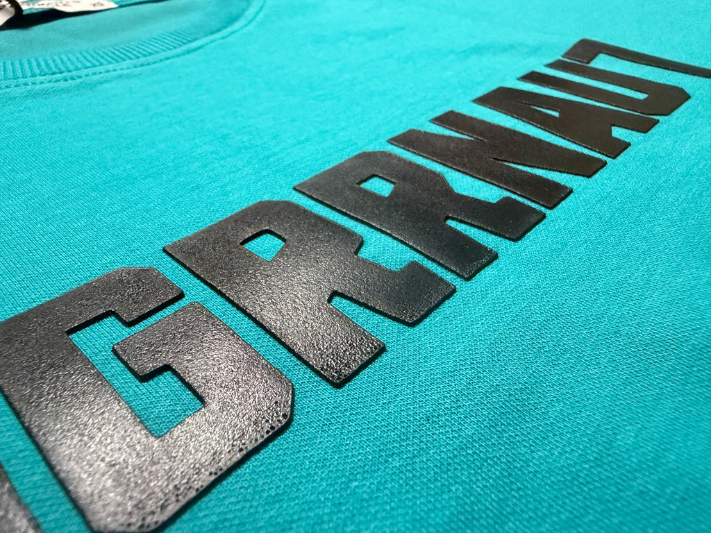 Teal tshirt with black logo on a turquoise background