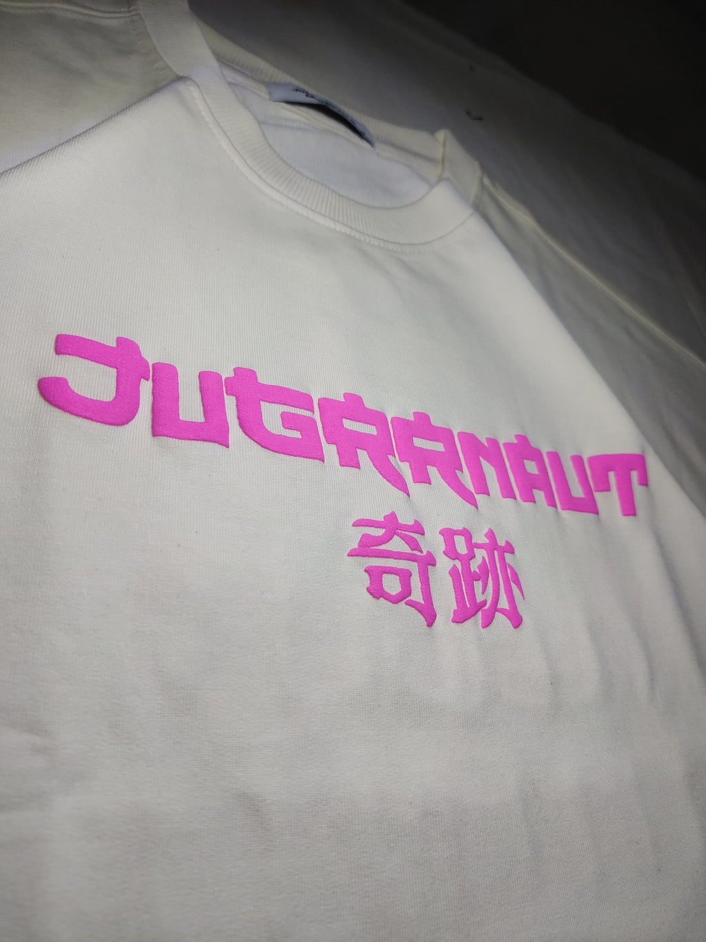 Beige Oversized tshirt with pink text on a plain background
