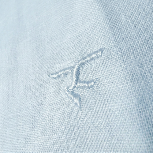 Close-up of a logo on a light blue fabric surface