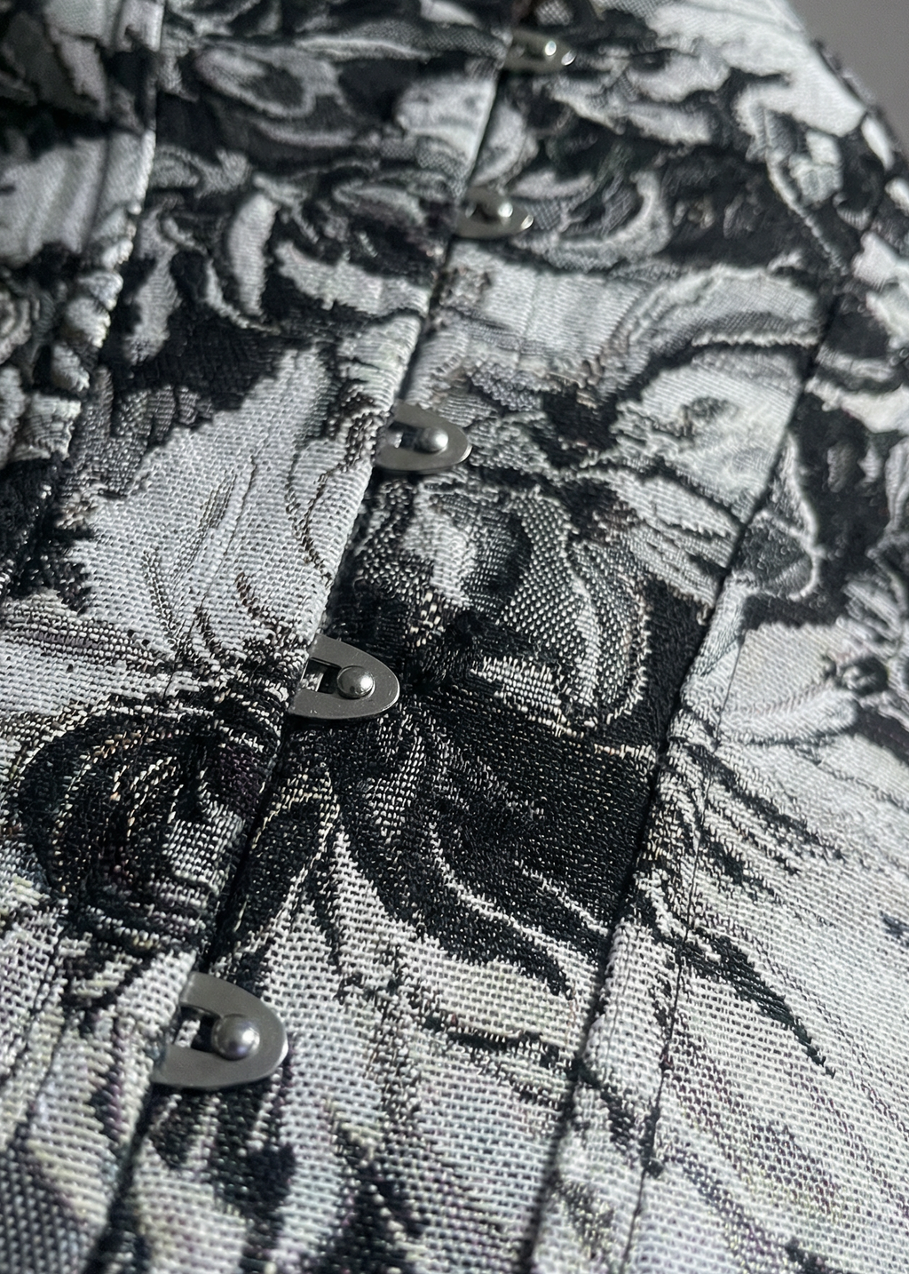 Close-up of a black and white floral patterned fabric with buttons.