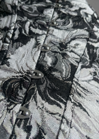 Close-up of a black and white floral patterned fabric with buttons.