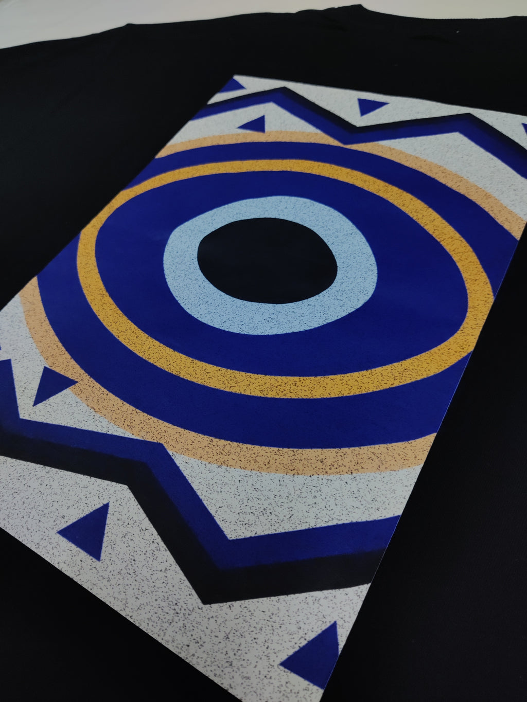 Close-up of an evil eye patterned fabric with blue, yellow, and black colors.