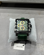 Green watch with detailed face on a gray surface, branded 'EXTRI'
