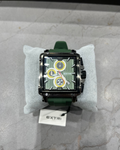 Green watch with a detailed face on a gray surface, branded 'EXTRI'.