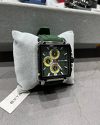 Watch with green strap on a gray cushion, brand 'Extri' visible