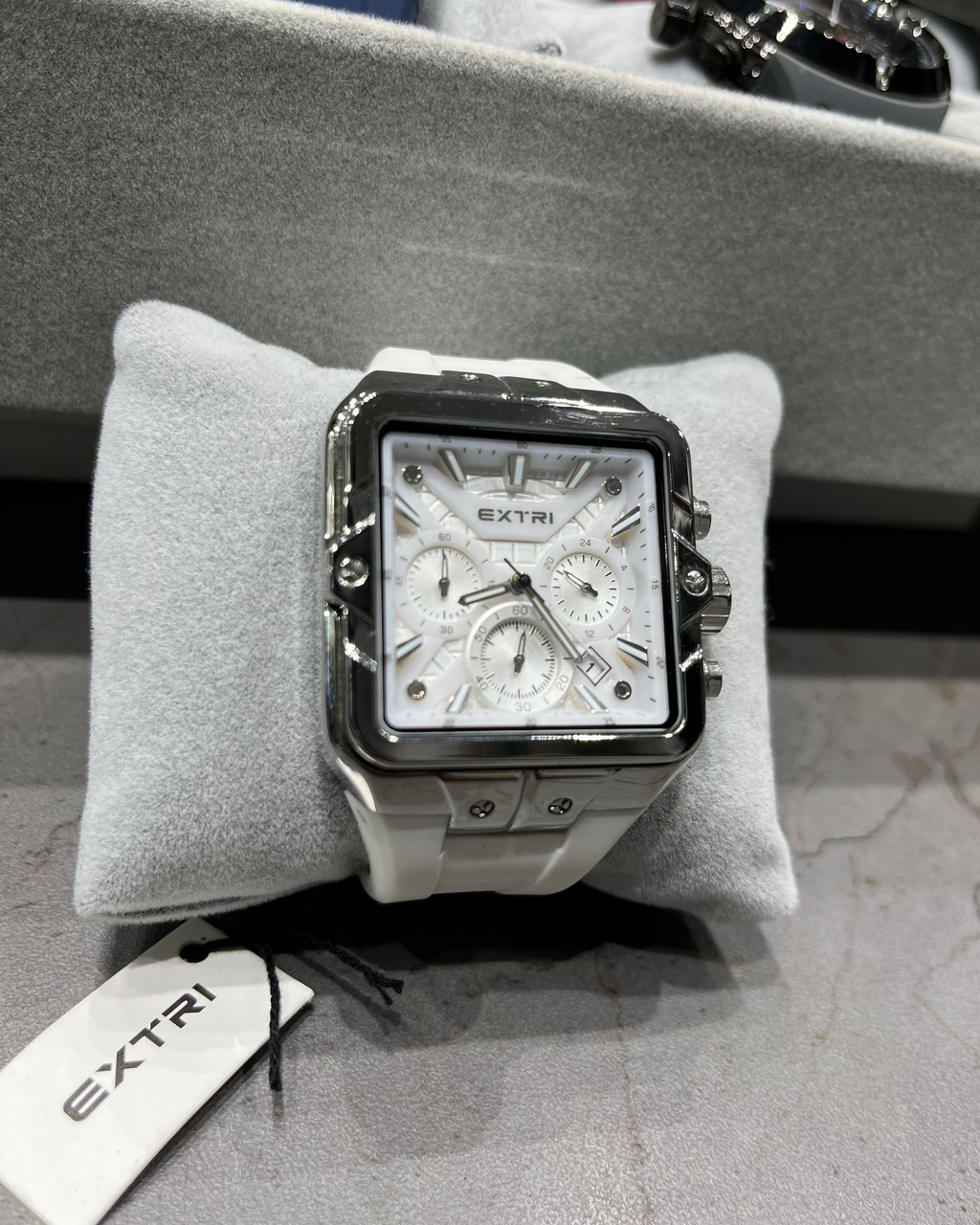 Watch on a gray cushion with 'EXTRI' tag in the background