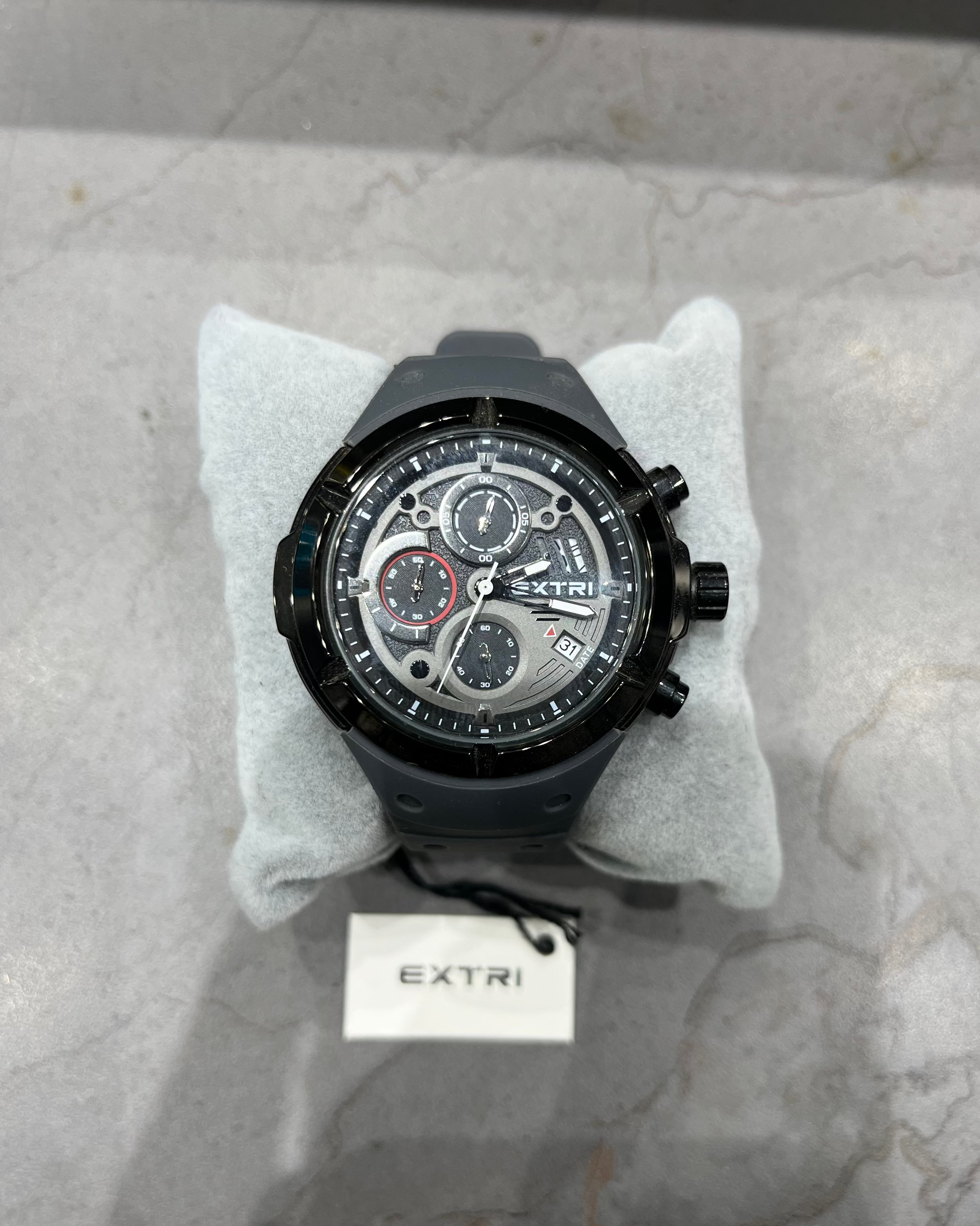 Black wristwatch with visible brand name on a marble surface