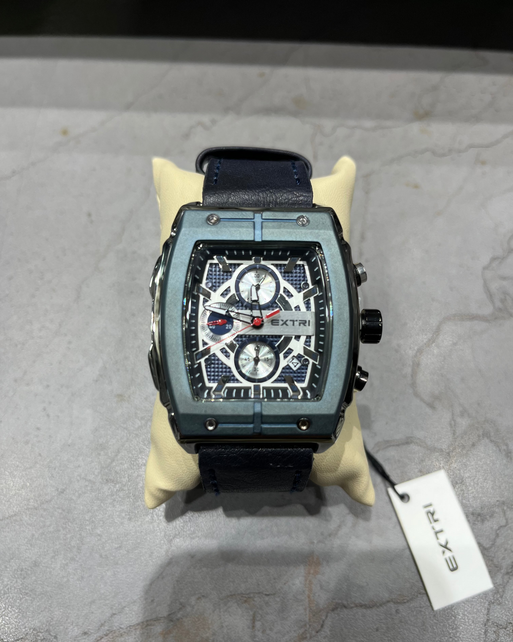 Luxury watch with a detailed face on a gray surface, featuring the brand 'Extri'.
