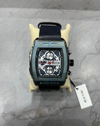 Luxury watch with a black strap on a gray surface, featuring the brand 'EXTRI'.