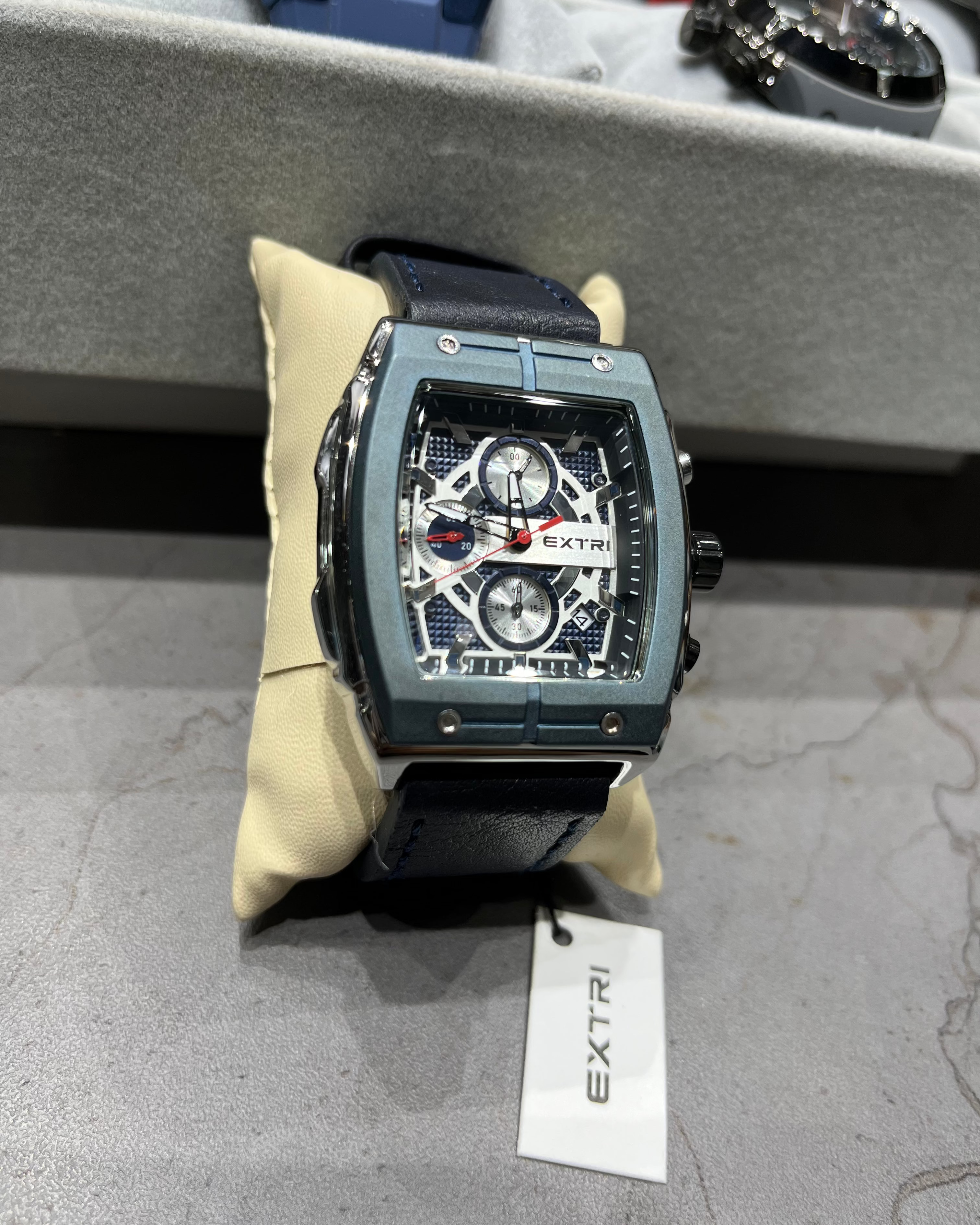 Luxury watch with visible brand name on a gray surface