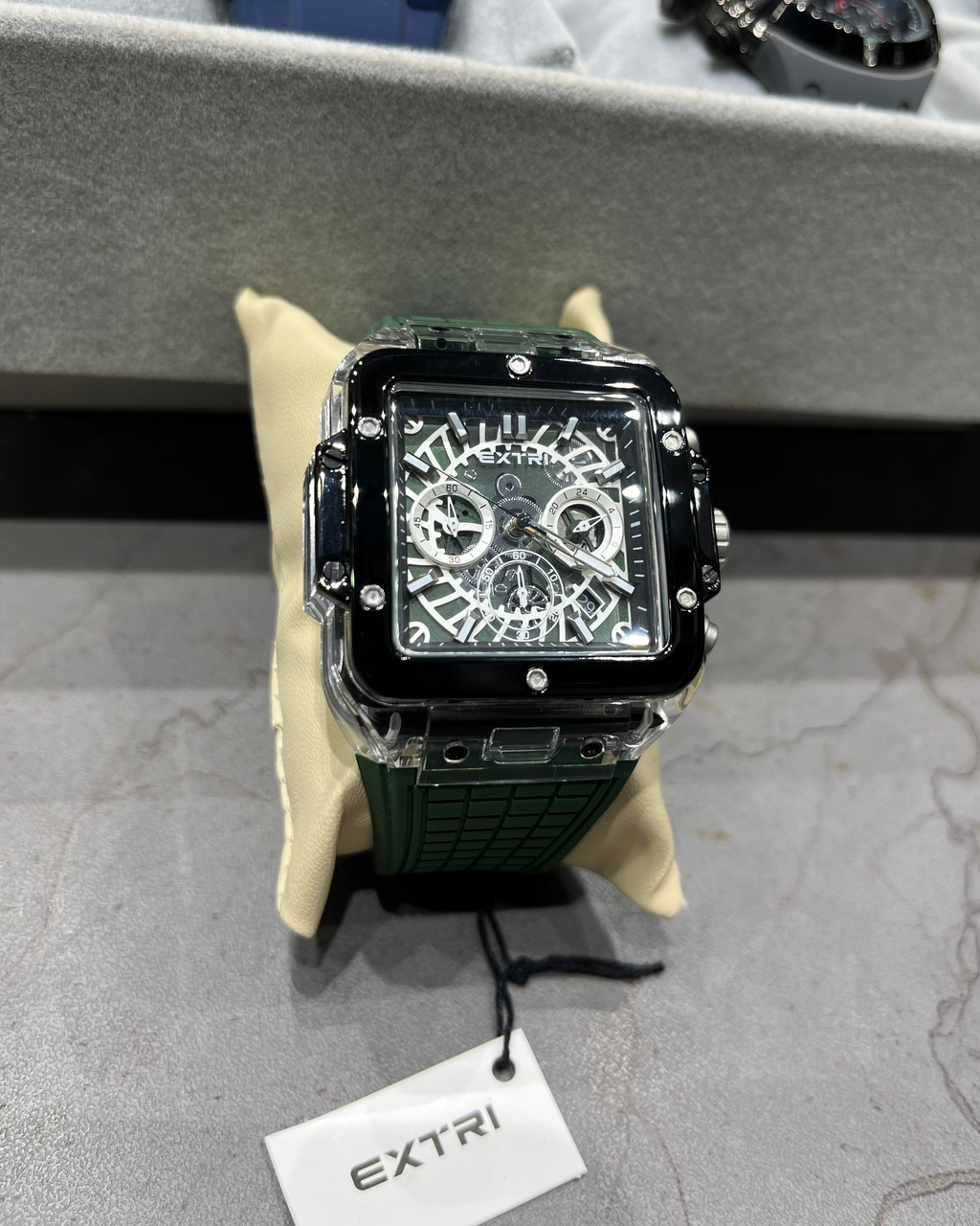 Luxury watch with intricate design on a gray surface, brand 'EXTRI' visible