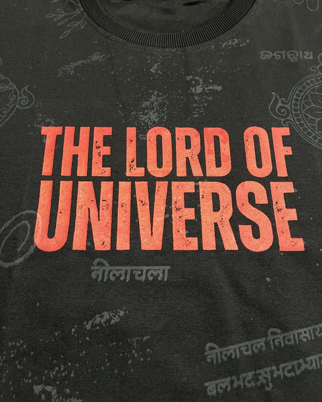 Black t-shirt with red text 'THE LORD OF UNIVERSE' on a dark background