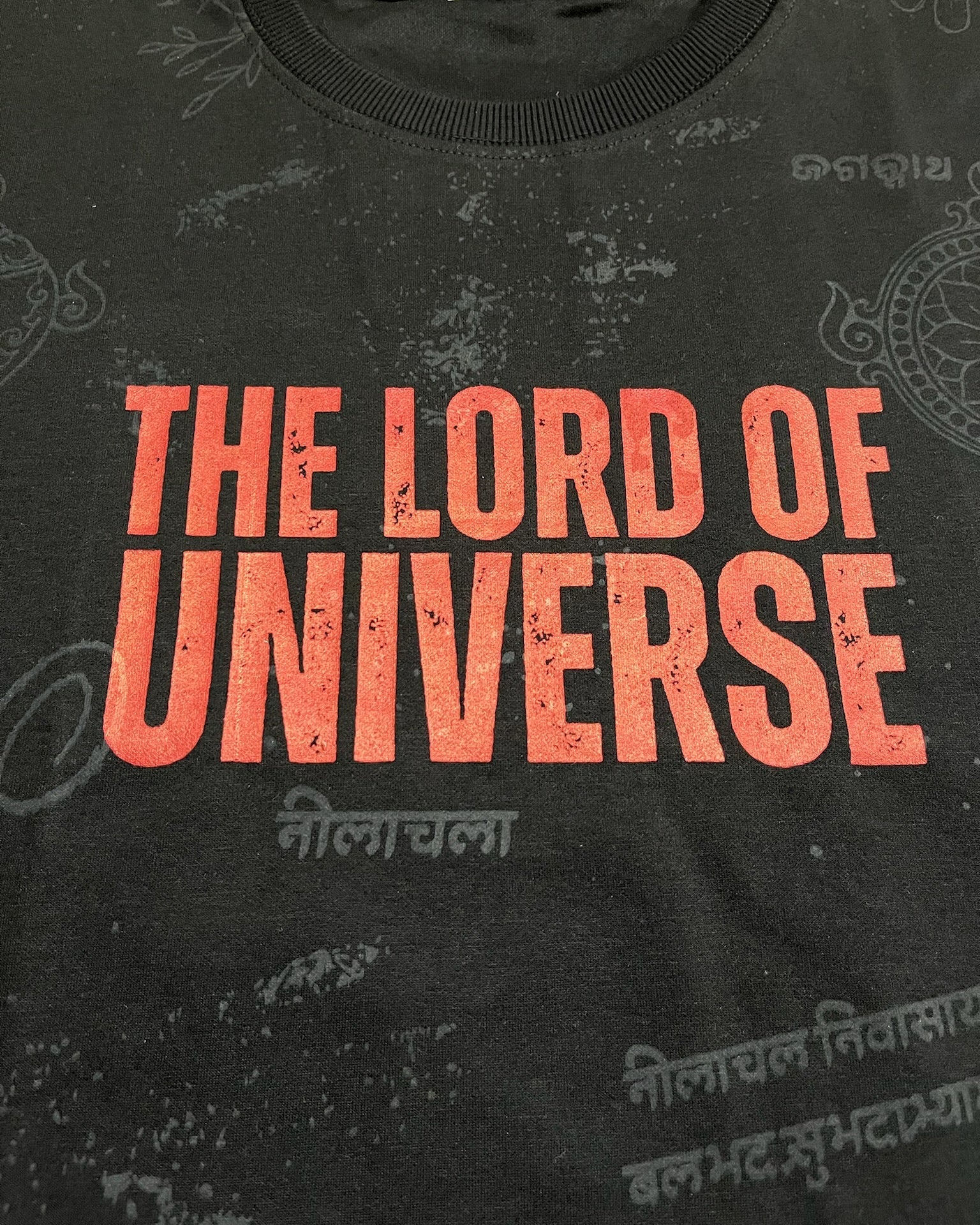 Black t-shirt with red text 'THE LORD OF UNIVERSE' on a dark background