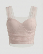Pink bralette with sheer mesh straps on a white background