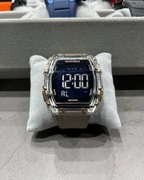Digital watch with clear and gold accents on a gray cushion, brand 'Naviforce' visible