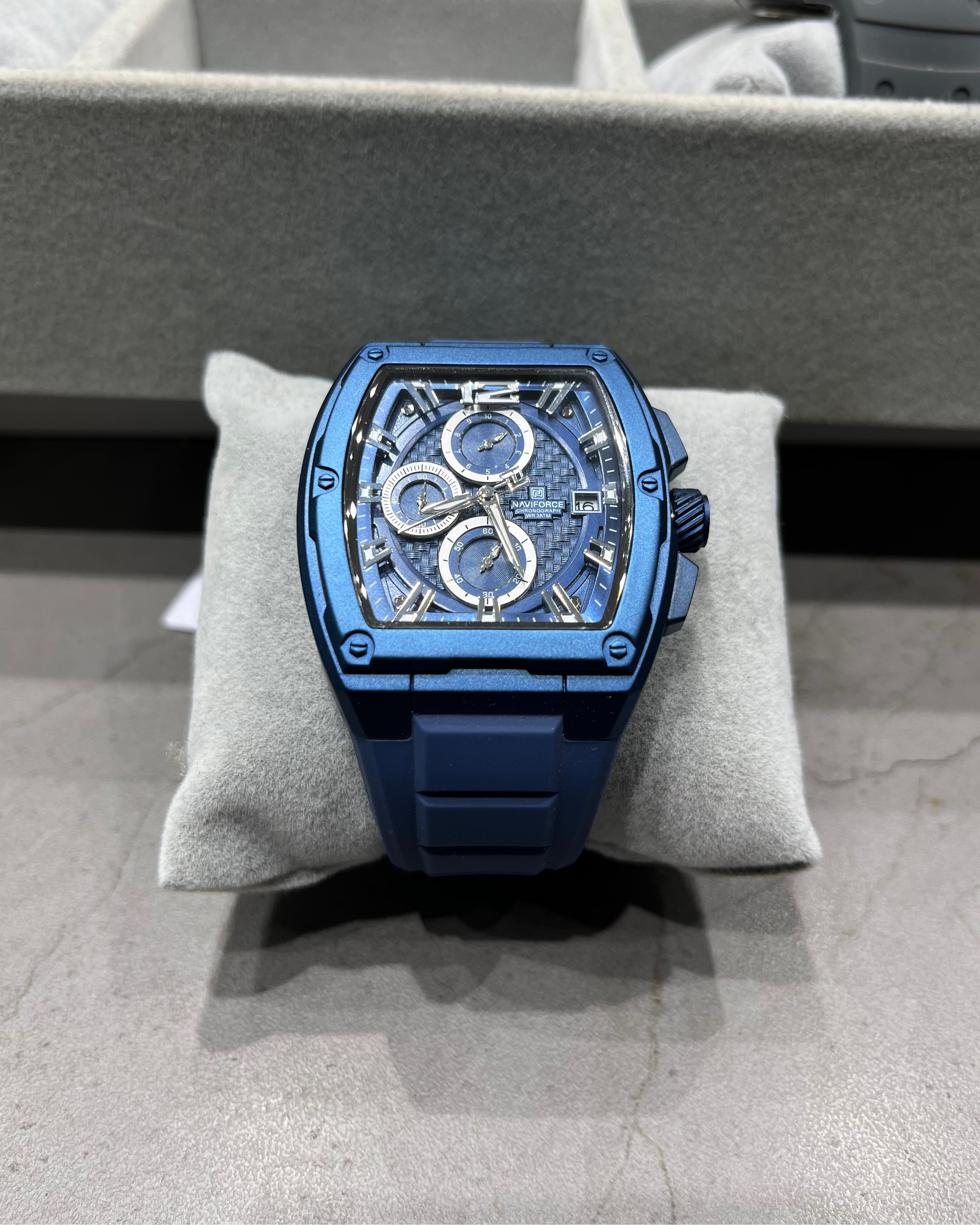 Blue watch on a gray cushion with a blurred background