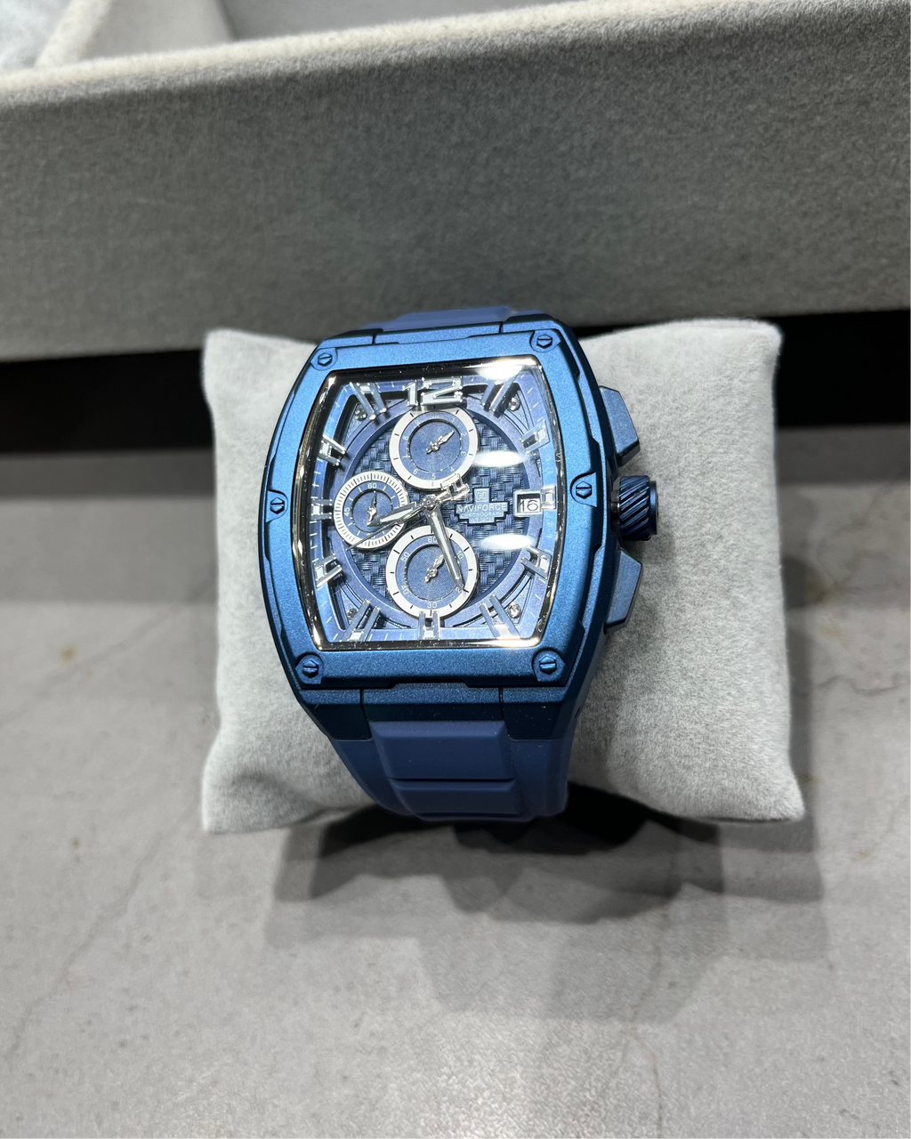 Blue watch on a gray cushion with a blurred background