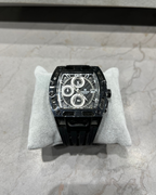 Black watch on a white cushion with a gray background