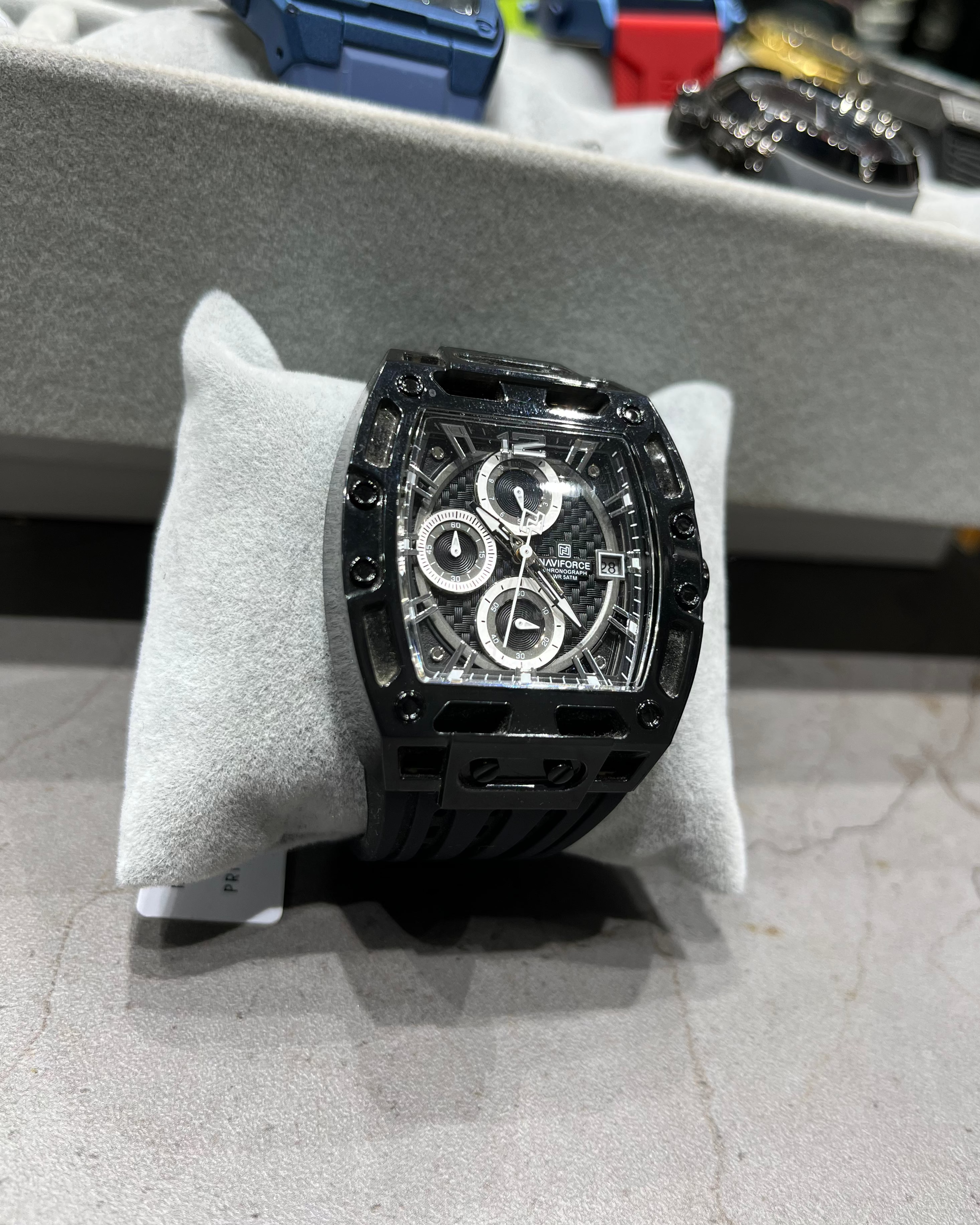 Black watch on a display stand with blurred background