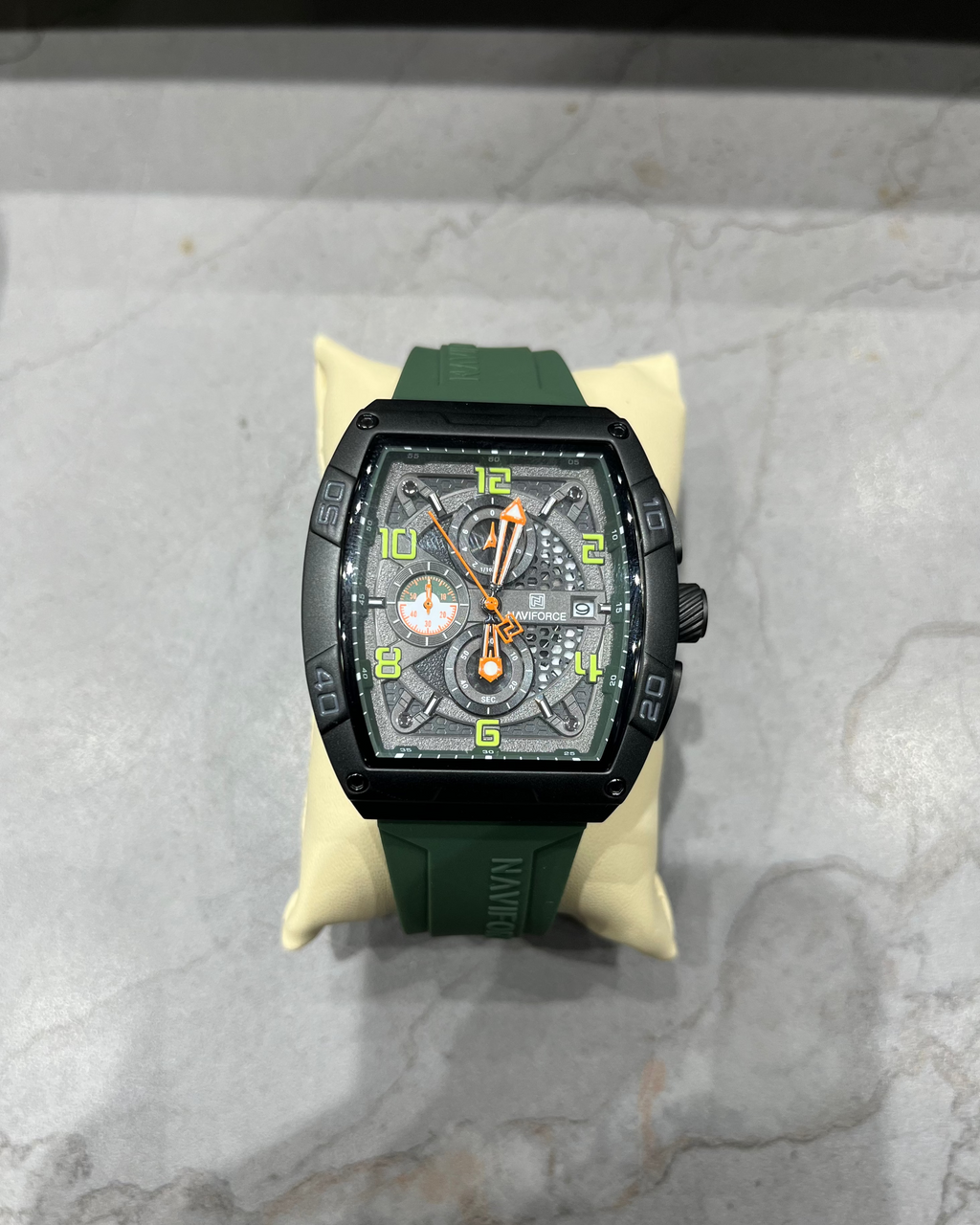 Luxury watch with green strap on a marble surface