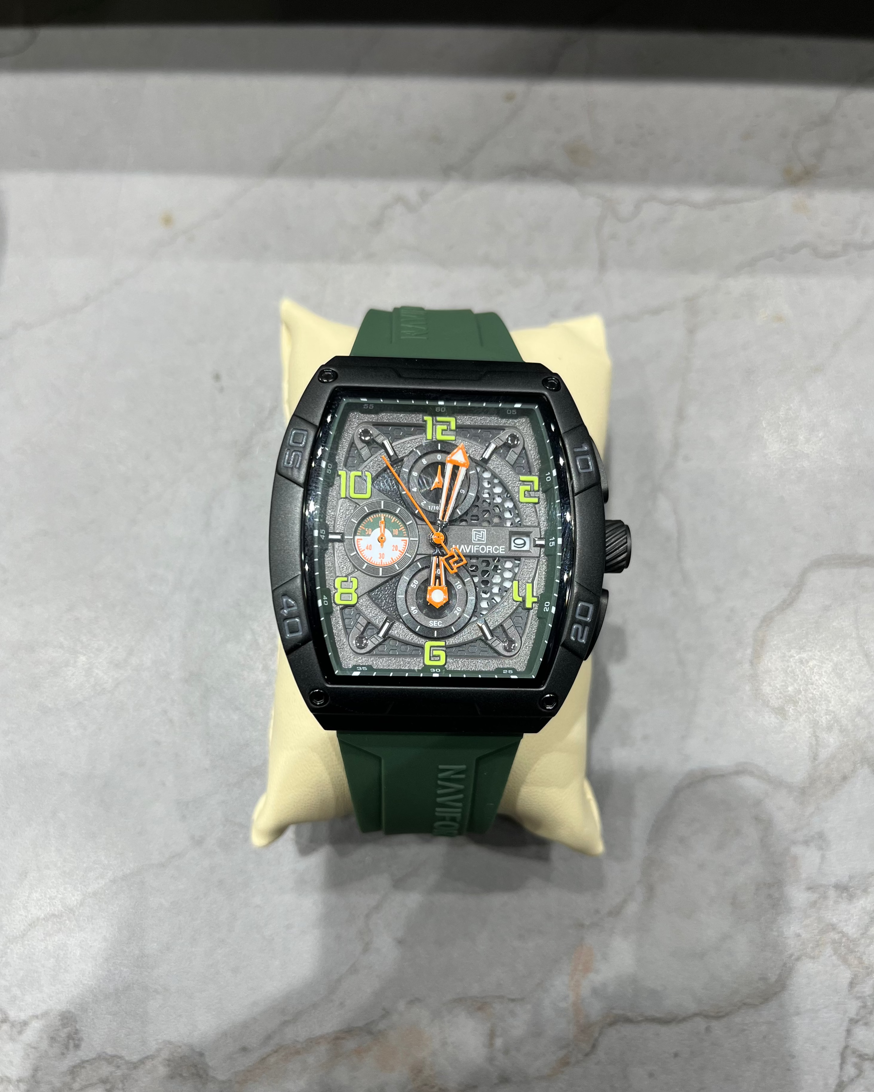 Luxury watch with green strap on a marble surface