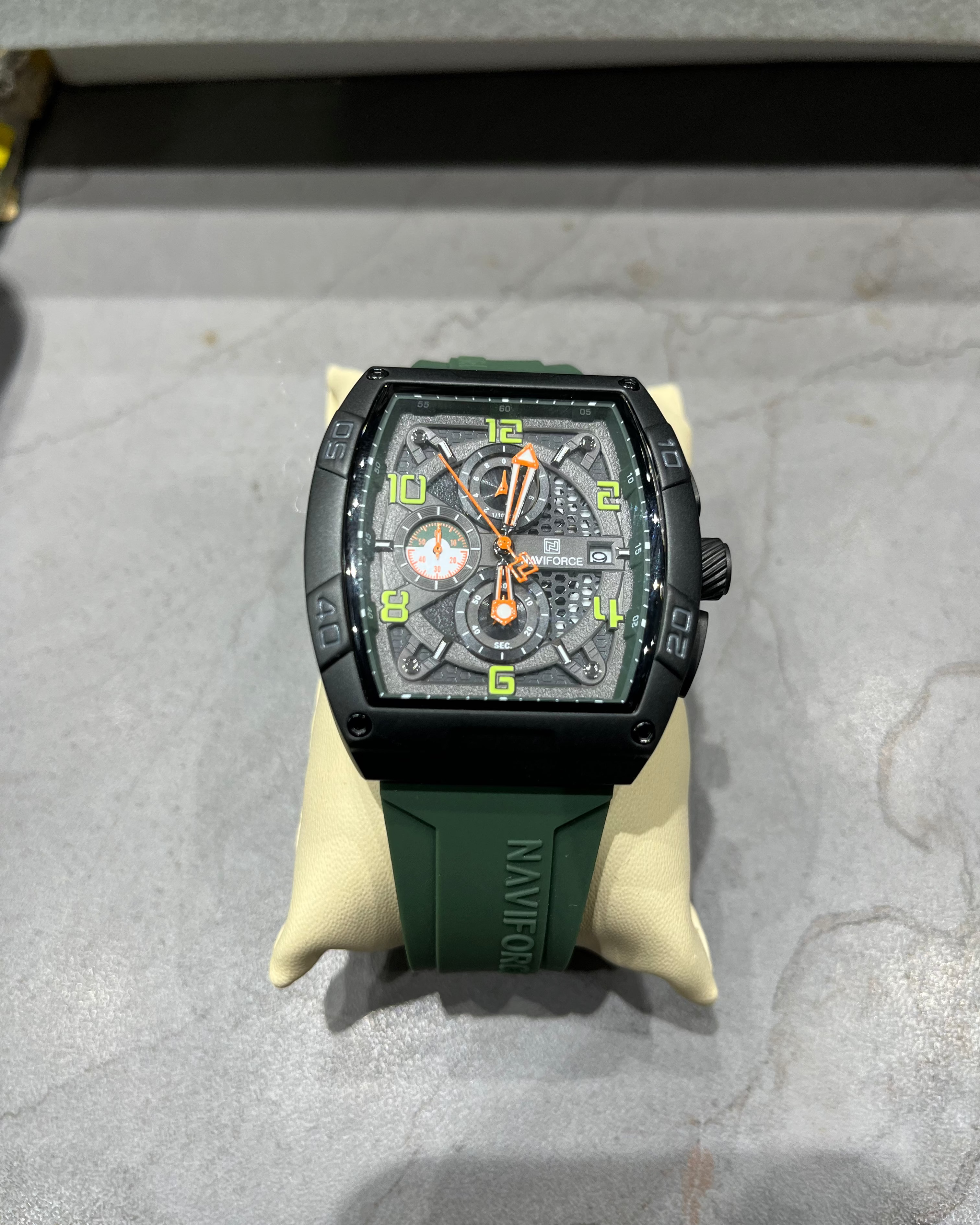 Wristwatch with green strap on a gray surface