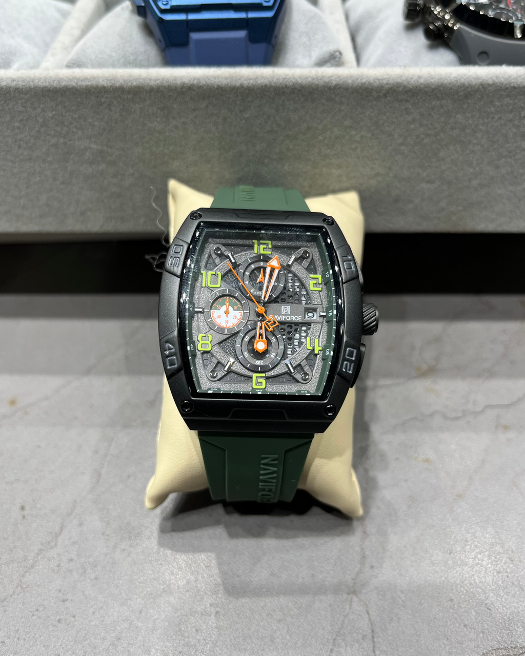 Green watch with a detailed face on a gray surface