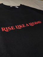 Black sweatshirt with 'Rise Like a Legend' text in red on a plain background