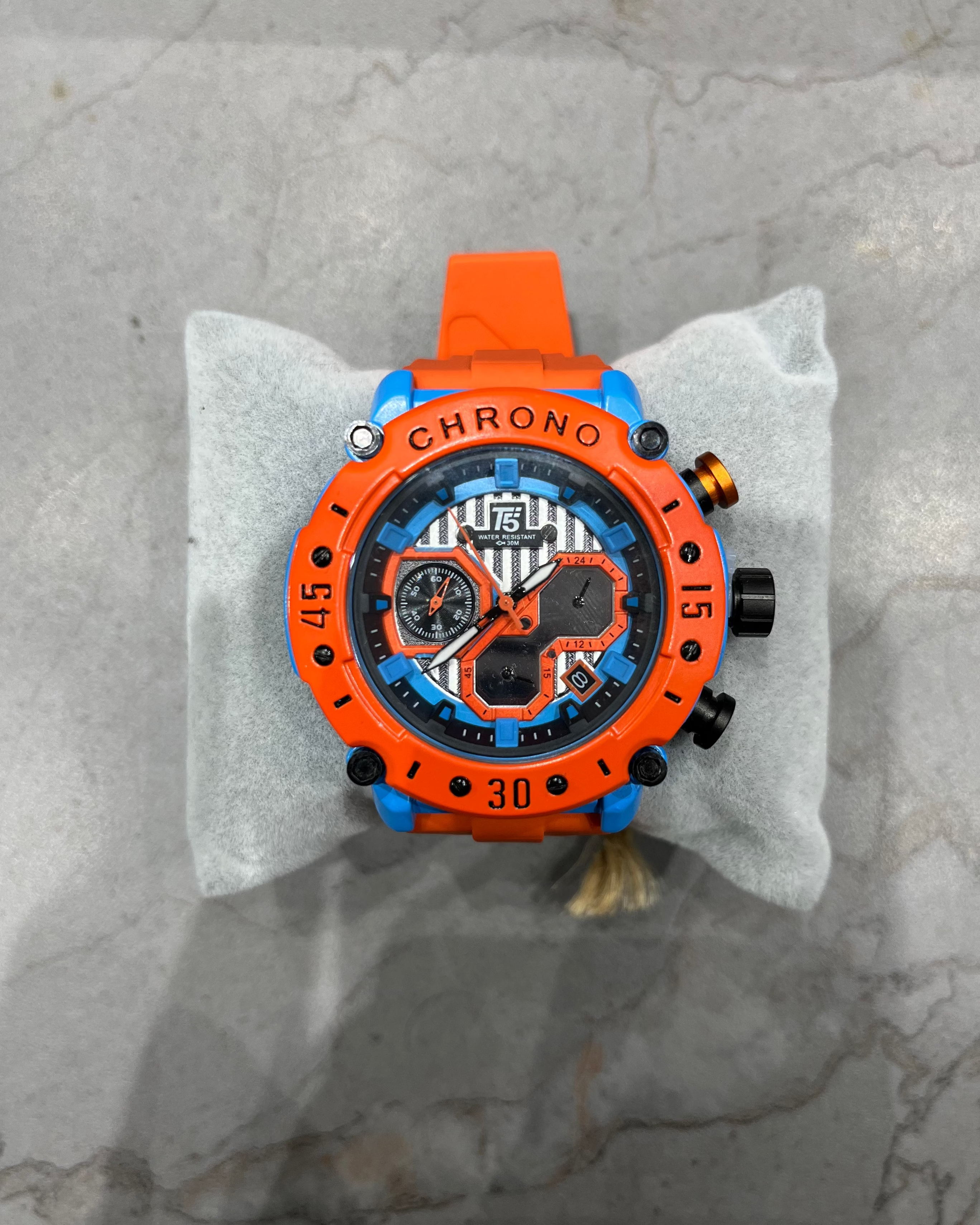 Orange and black watch on a gray marble surface