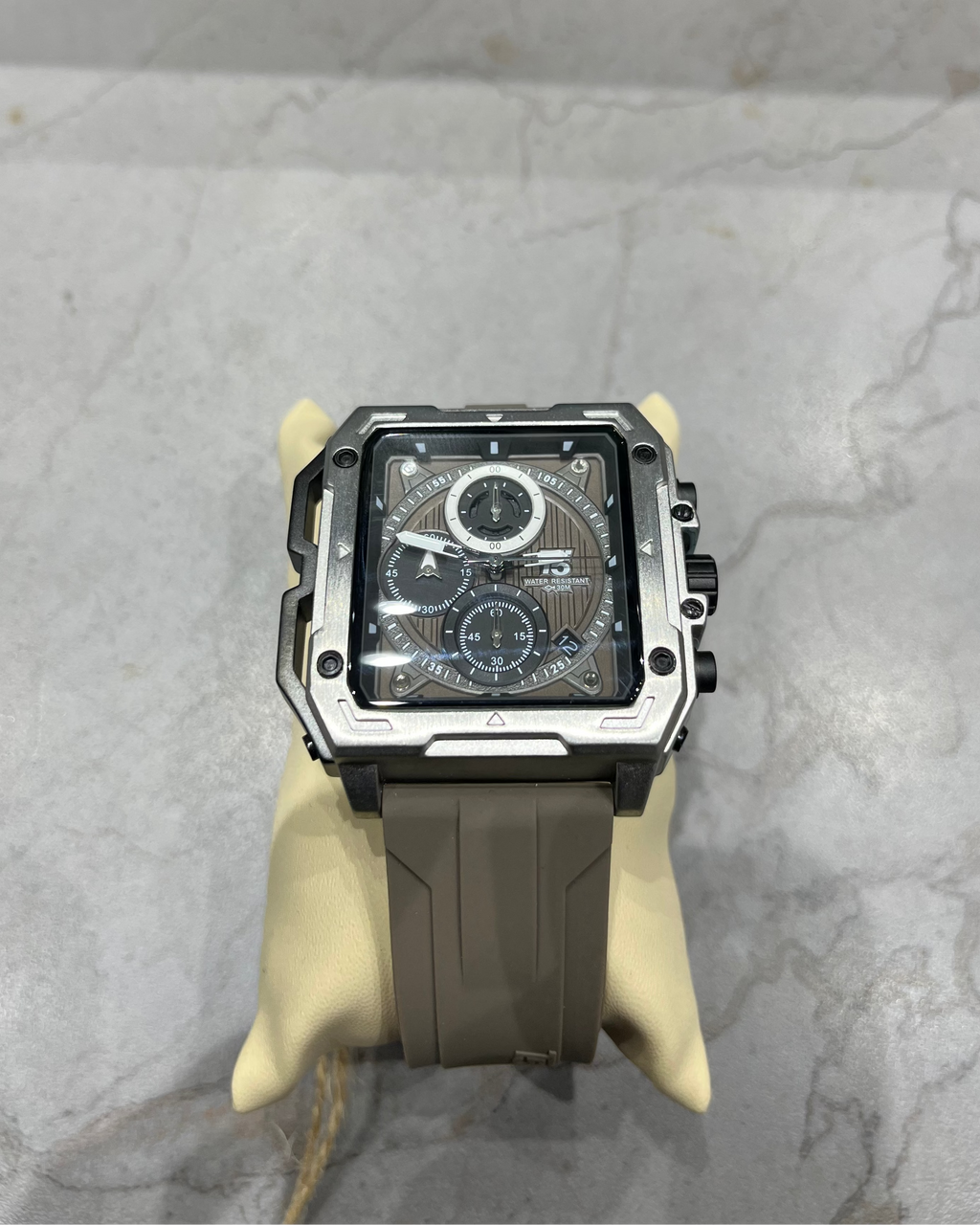 Watch with a black strap on a gray marble surface