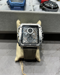 Luxury watch with transparent case back on a gray surface